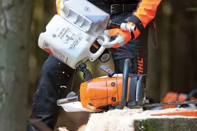 Persona rellenando el depósito de una motosierra Stihl con un bidón combinado